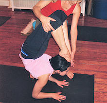 Son Hui helps a student reach a proper alignment